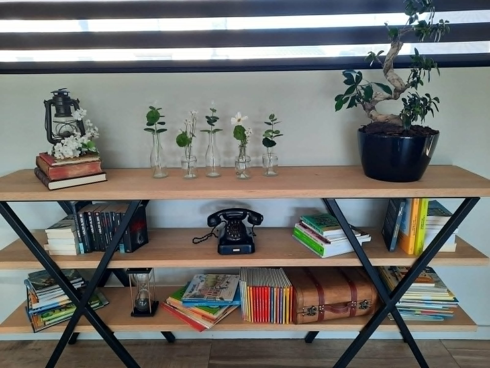 Console-bibliothèque à trois tablettes en chêne posées sur un piètement en acier noir en X